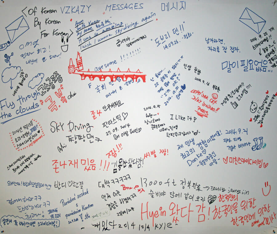 VZKAZY, MESSAGES, 메시지라는 세 언어 제목이 적힌 Skydive Kantor 격납고의 메시지 벽
